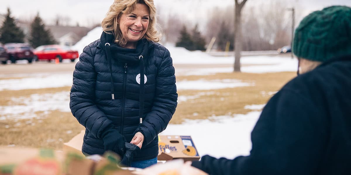 Volunteer Helping Person Facing Food Insecurity With Food