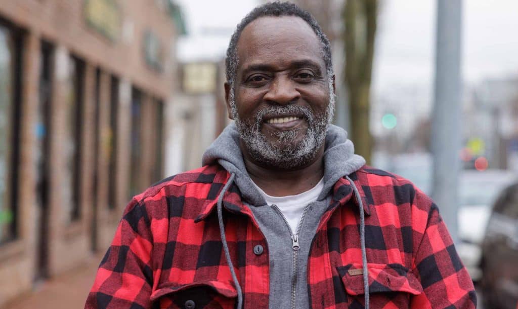 Man Standing On Sidewalk Smiling